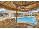 Charming tiki bar with ceiling fan overlooks the sparkling pool and rock waterfall for ultimate relaxation at 3892 Pasilla Ave, Las Vegas, NV 89118
