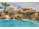 Stunning waterfall feature with slide flows into the refreshing pool, creating a tropical oasis at 3892 Pasilla Ave, Las Vegas, NV 89118