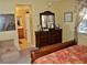 Tastefully decorated bedroom includes dresser with mirror and view into en-suite bathroom at 4047 Cougar Falls Ct, North Las Vegas, NV 89085
