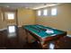 View of the billiard room with its pool table with billiard sticks, hardwood floors, and natural light at 4047 Cougar Falls Ct, North Las Vegas, NV 89085