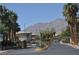 Gated neighborhood entrance with lush palm trees and scenic mountain views in the background at 4047 Cougar Falls Ct, North Las Vegas, NV 89085