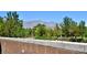 Community view with brick wall, mountains in the background, and lush greenery at 4047 Cougar Falls Ct, North Las Vegas, NV 89085
