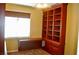 A Home office with a built-in bookcase and desk near a bright window with blinds at 4047 Cougar Falls Ct, North Las Vegas, NV 89085