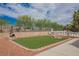 Landscaped backyard featuring a faux grass lawn, brickwork details, and a partial view of the in-ground pool at 4384 Grey Spencer Dr, Las Vegas, NV 89141
