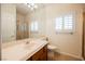 Well-lit bathroom has a large mirror, white cabinets, a walk-in shower, and a tile floor at 4384 Grey Spencer Dr, Las Vegas, NV 89141