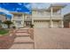 Two-story home with tile roof, three-car garage, and paved driveway and walkway at 4384 Grey Spencer Dr, Las Vegas, NV 89141