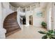 Bright, two-story foyer featuring a curved staircase, tile flooring, and double-door entry at 4384 Grey Spencer Dr, Las Vegas, NV 89141