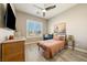 Comfortable bedroom with natural light, wood-look floors, and a ceiling fan for added comfort at 4772 Se Argent Hills Ave, Pahrump, NV 89061