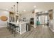 A modern kitchen features gray cabinets, an island with bar seating, and stainless steel appliances at 4772 Se Argent Hills Ave, Pahrump, NV 89061