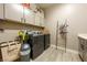 Well-equipped laundry room with modern washer, dryer, gray cabinets, and convenient storage solutions at 4772 Se Argent Hills Ave, Pahrump, NV 89061