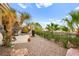 Lush backyard with desert landscaping, mature trees, and a relaxing patio area at 482 Bonnie Brook Pl, Henderson, NV 89012
