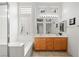 Bright bathroom featuring glass block window above a bathtub and double sink vanity at 482 Bonnie Brook Pl, Henderson, NV 89012