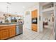 Well-lit kitchen featuring stainless steel dishwasher and a view into the living space at 482 Bonnie Brook Pl, Henderson, NV 89012