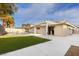 A tranquil backyard with a covered patio, swimming pool, and manicured synthetic lawn at 4842 Plata Del Sol Dr, Las Vegas, NV 89121