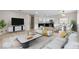 Bright, open-plan living space featuring a large flat-screen TV, modern decor and an adjoining kitchen at 4842 Plata Del Sol Dr, Las Vegas, NV 89121