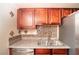Close-up of kitchen with stainless sink, mosaic tile backsplash, and wooden cabinets at 5000 Indian River Dr # 475, Las Vegas, NV 89103
