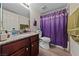 Cozy bathroom features a single sink, granite countertops, tiled floors, and shower with purple curtain at 5180 Indian River Dr # 355, Las Vegas, NV 89103