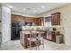 Well-lit kitchen featuring ample dark wood cabinetry, granite countertops, and stainless steel appliances at 5588 Holcomb Bridge Ct, Las Vegas, NV 89149