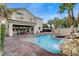 Backyard pool with a rock waterfall feature adjacent to the covered patio of this two-story home at 5588 Holcomb Bridge Ct, Las Vegas, NV 89149