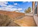 The backyard patio features gravel landscaping, a concrete pad, and a tall brick wall for privacy at 576 Bayo Canyon Ct, Henderson, NV 89015