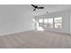 Spacious bedroom with carpeted floors, ceiling fan, and large windows at 6214 Ebony Legends Ave, Las Vegas, NV 89131