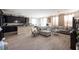Open concept living area featuring stylish gray flooring, a large sectional, and a breakfast bar to kitchen at 6487 W Levi Ave, Las Vegas, NV 89141