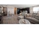 Spacious open floor plan with sleek gray flooring, a plush sectional sofa, and seamless flow to kitchen at 6487 W Levi Ave, Las Vegas, NV 89141