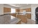 Kitchen with granite countertops, wood cabinets, modern appliances, and a central island at 8036 Maple Park St, Las Vegas, NV 89131
