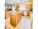 Well-lit kitchen with island, wood cabinets, tile flooring, and appliances at 8036 Maple Park St, Las Vegas, NV 89131