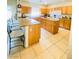 Bright kitchen features tile flooring, wood cabinets, an island and seating at 8036 Maple Park St, Las Vegas, NV 89131