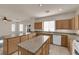 A modern kitchen features ample granite countertops, a central island, and wood cabinetry at 8036 Maple Park St, Las Vegas, NV 89131
