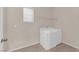 A bright laundry room with a window, tile floor, shelving, and a modern washer/dryer unit at 8036 Maple Park St, Las Vegas, NV 89131