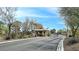 Gated community entrance with mature trees and well-maintained landscaping at 8112 Golfers Oasis Dr, Las Vegas, NV 89149