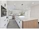 Modern kitchen with large island, white cabinets, stainless appliances and large window at 8112 Golfers Oasis Dr, Las Vegas, NV 89149