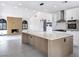 Modern kitchen with stainless appliances, large island and view to the fireplace wall at 8112 Golfers Oasis Dr, Las Vegas, NV 89149