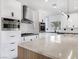 Bright kitchen showcases white cabinetry, modern lighting, stainless appliances, and an island with seating at 8112 Golfers Oasis Dr, Las Vegas, NV 89149
