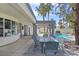 Covered patio with comfortable seating overlooks the inviting pool and lush backyard at 8112 Golfers Oasis Dr, Las Vegas, NV 89149