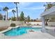 Inviting pool with stone accents and lush landscaping offers a tranquil backyard retreat at 8112 Golfers Oasis Dr, Las Vegas, NV 89149