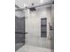 Modern shower featuring glass door and wall with built-in shelves at 8112 Golfers Oasis Dr, Las Vegas, NV 89149