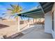 View of the covered patio area, featuring a concrete pad, with palm trees and desert landscaping at 819 Teal Wing Way, Henderson, NV 89002