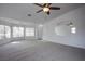 Spacious living room with neutral carpet, ample natural light, and a ceiling fan at 819 Teal Wing Way, Henderson, NV 89002