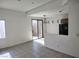 Open living area with tile floors, glass door to patio and access to the kitchen at 8301 Strawberry Spring St, Las Vegas, NV 89143