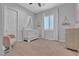 Bedroom with a white crib, neutral carpet, and cozy chair near a bright window at 9035 Chiffon Mist Ave, Las Vegas, NV 89129