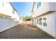 Fully fenced backyard with gravel, covered patio, and functional layout between neighboring homes at 9092 Sosa Creek Ave, Las Vegas, NV 89149