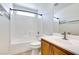 Bright bathroom featuring a tiled shower-over-tub, single sink with wood cabinets, and natural light at 9092 Sosa Creek Ave, Las Vegas, NV 89149