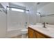 Bathroom featuring neutral tile floors, tub, and a wood vanity with solid surface countertop at 9092 Sosa Creek Ave, Las Vegas, NV 89149