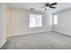 Spacious bedroom featuring neutral carpet, a ceiling fan, and abundant natural light from two windows at 9092 Sosa Creek Ave, Las Vegas, NV 89149