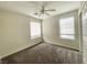 Bright bedroom with neutral carpet, a ceiling fan, and two windows at 9092 Sosa Creek Ave, Las Vegas, NV 89149