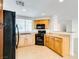 Well-lit kitchen with black appliances, light wood cabinets and recessed lighting at 9092 Sosa Creek Ave, Las Vegas, NV 89149