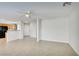 Spacious living room featuring neutral tile flooring, a ceiling fan, and access to the kitchen at 9092 Sosa Creek Ave, Las Vegas, NV 89149